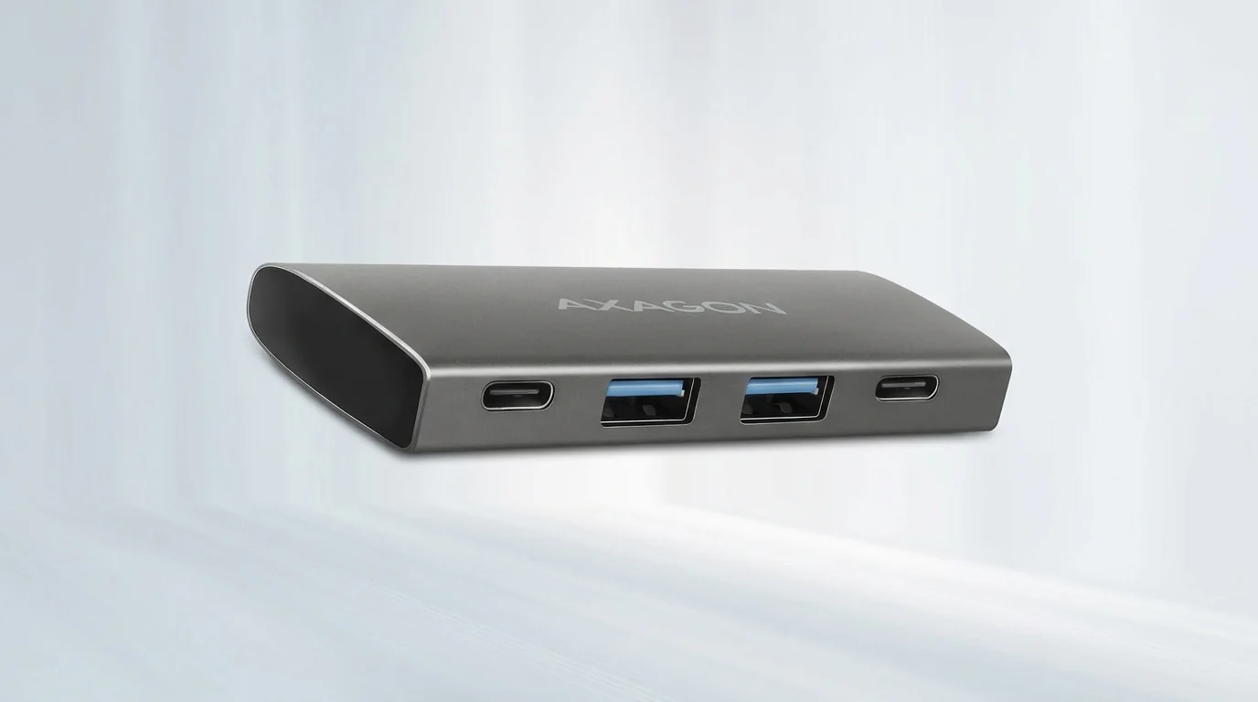Sivý hliníkový USB hub AXAGON s dvoma USB-C a dvoma USB-A portmi na prednej strane.