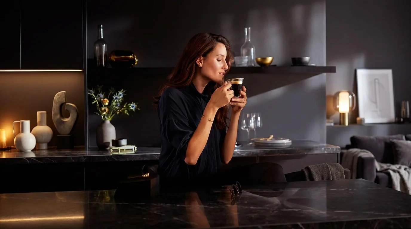 Žena v elegantním tmavém interiéru si vychutnává šálek kávy L'OR Lungo Profondo.