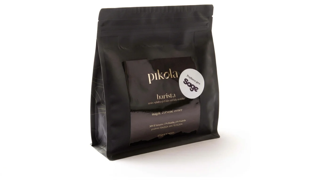 Černé balení zrnkové kávy Pikola Barista s bílou kulatou samolepkou s nápisem Praženo pro Sage.