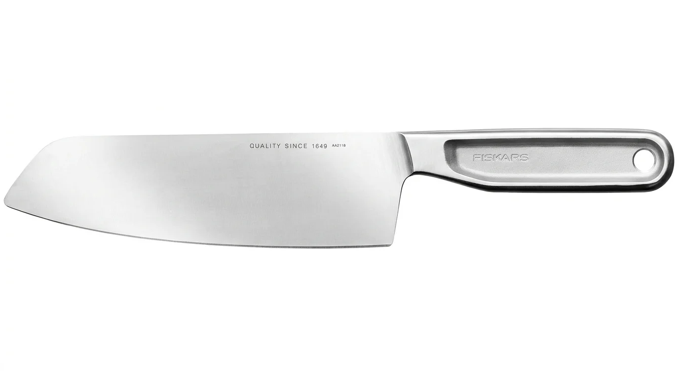 Celokovový nůž Fiskars Santoku s širokou nerezovou čepelí a tvarovanou rukojetí s otvorem.