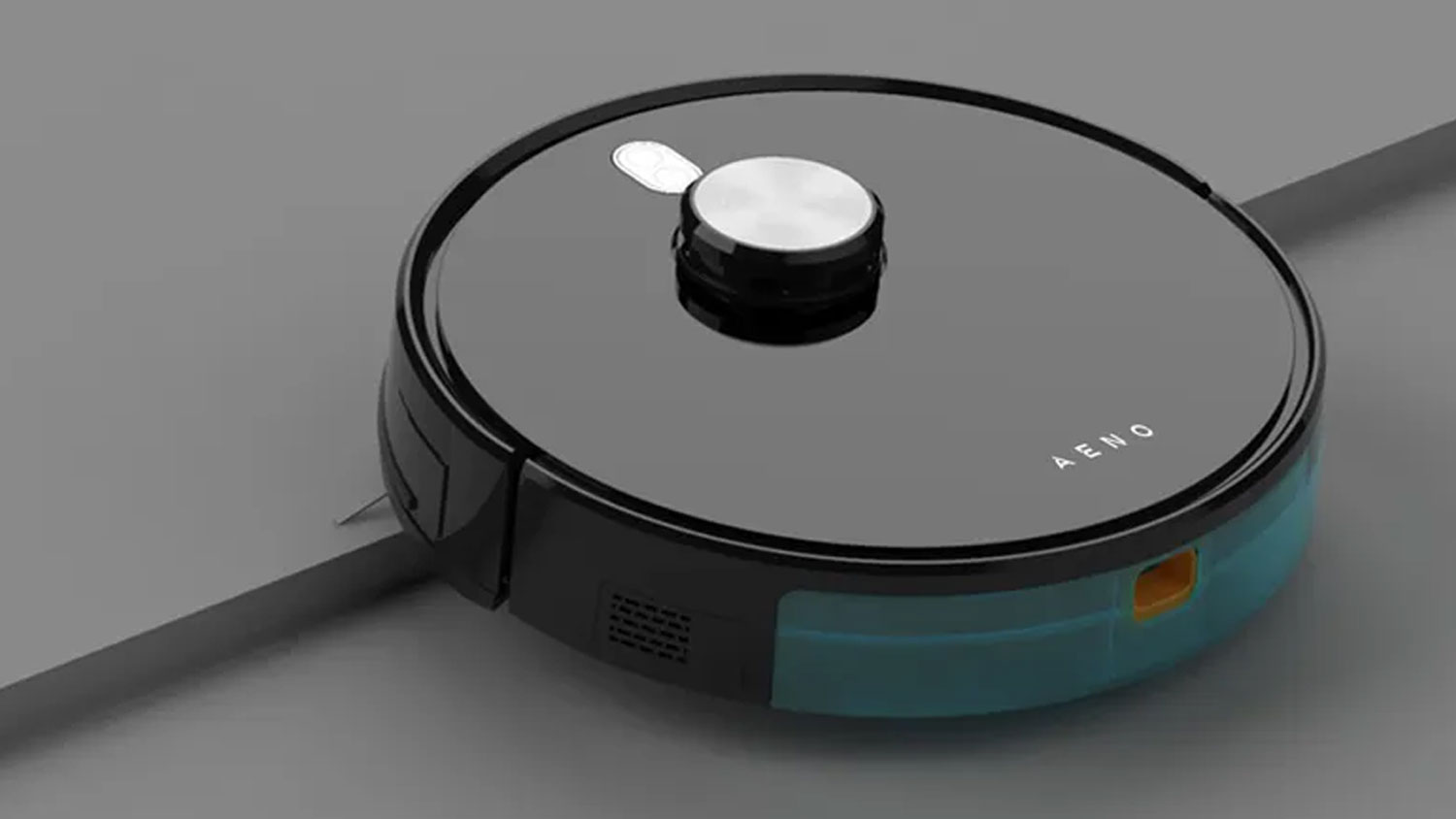Černý robotický vysavač AENO RC1S s modrou poloprůhlednou nádržkou na šedém povrchu.