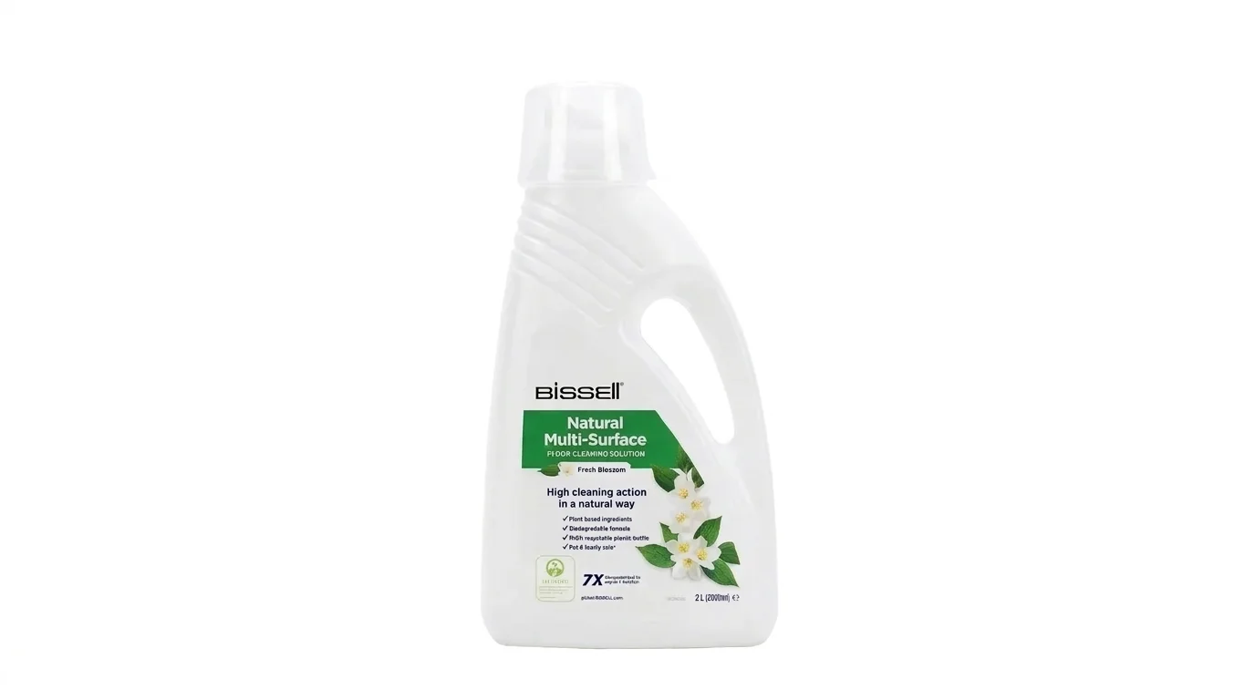 Bílá plastová láhev čisticího přípravku Bissell Natural Multi-Surface s uchem, průhledným uzávěrem a etiketou s vyobrazením bílých květů.