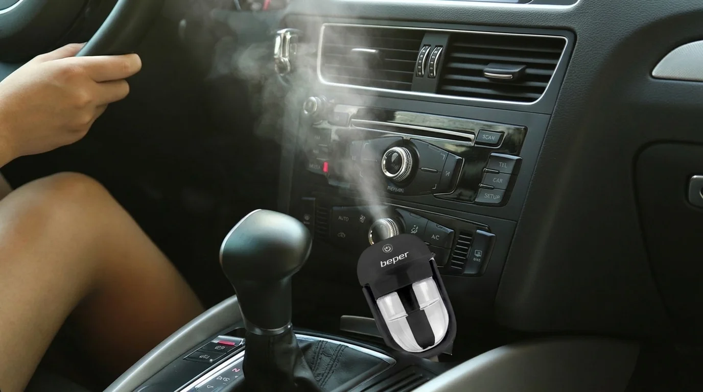 Černý aroma difuzér Beper zapojený v autě vypouští jemnou páru do interiéru.
