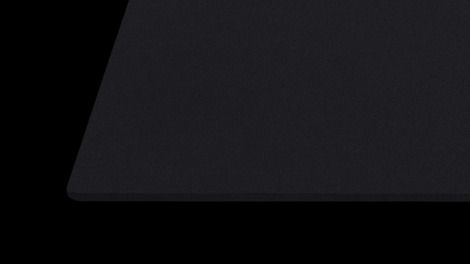 Detail zaobleného rohu a černého textilního povrchu podložky pod myš Logitech G740 L.