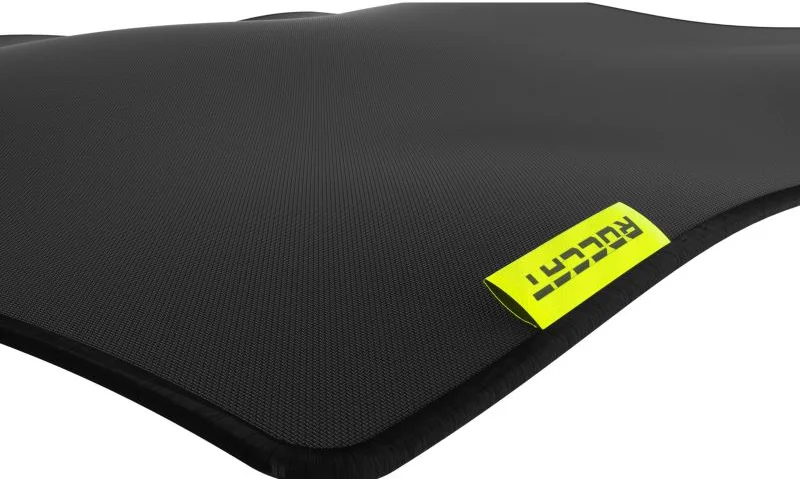 Detail černého povrchu podložky ROCCAT Sense Pro XXL s obšitým okrajem a žlutým štítkem s logem.