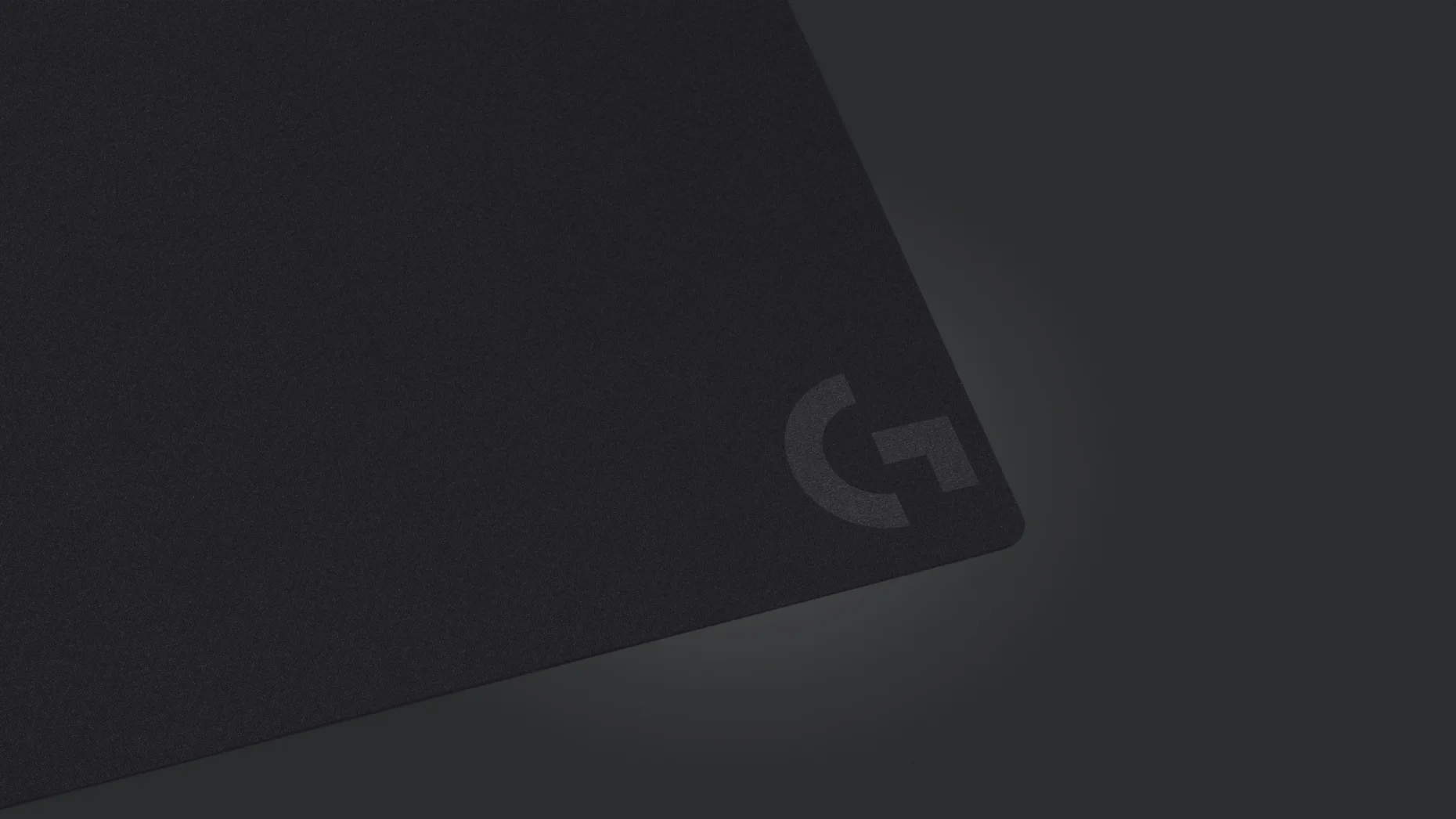 Detail rohu černé textilní podložky pod myš Logitech G240 s natištěným logem G.