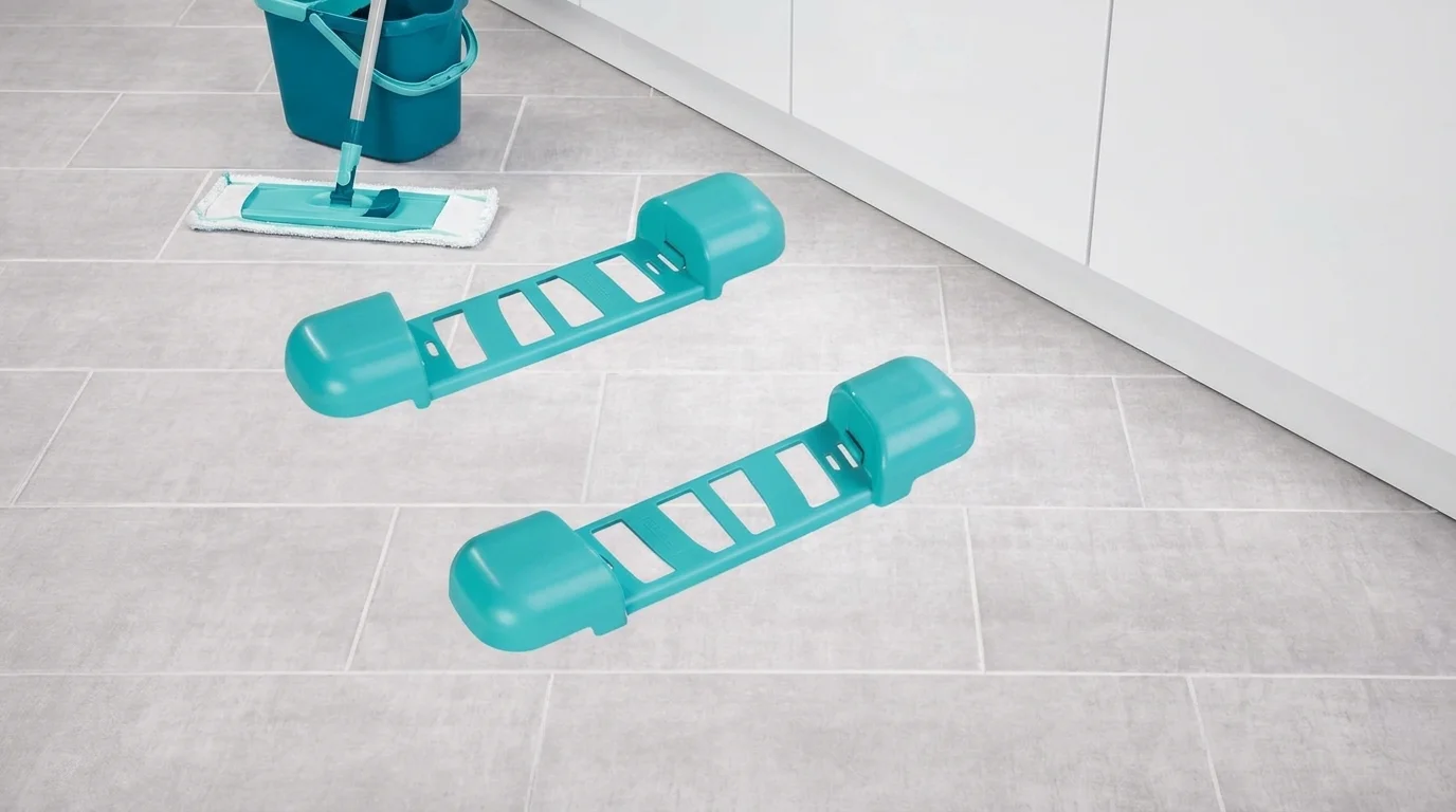 Tyrkysové díly vozíku k vědru Leifheit Clean Twist položené na dlažbě vedle mopu s kbelíkem.