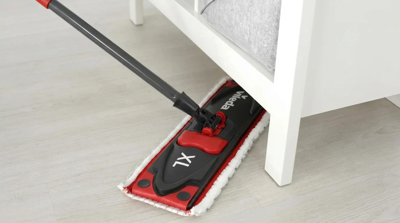 Plochý mop Vileda Ultramax XL pri umývaní svetlej podlahy pod nízkym bielym nábytkom.