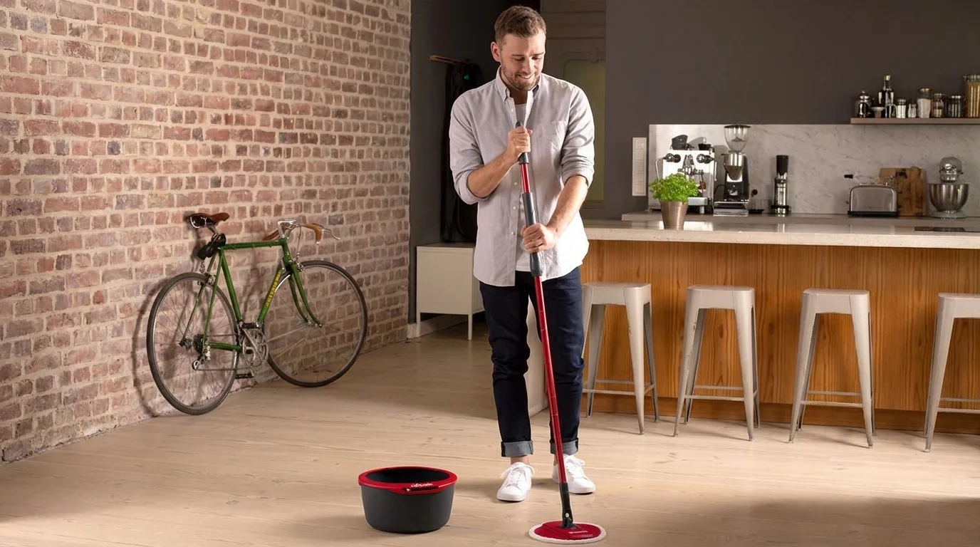 Muž vytírá podlahu mopem ze sady Vileda Spin & Clean s kbelíkem položeným opodál.