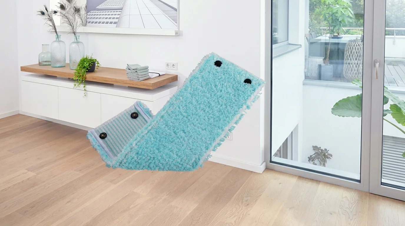 Světle modrý náhradní návlek na mop Leifheit Twist XL Sensitive s patentkami na pozadí interiéru s dřevěnou podlahou.