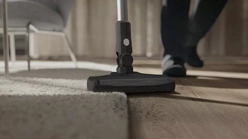 Hubica tyčového vysávača Electrolux pri vysávaní na prechode medzi kobercom a podlahou.