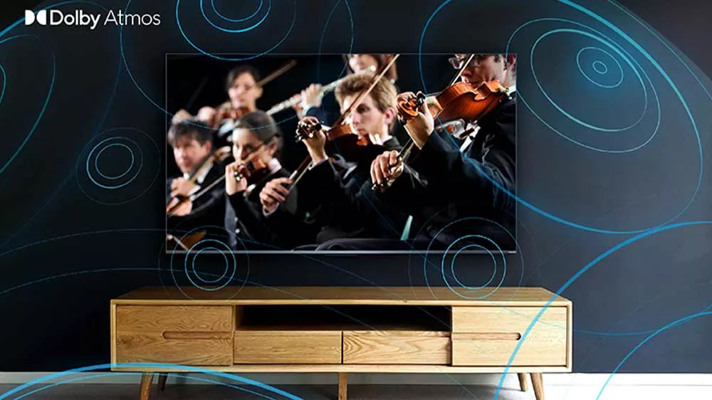 Televízor TCL s obrazom hrajúceho orchestra nad drevenou komodou so zvukovými vlnami a logom Dolby Atmos.