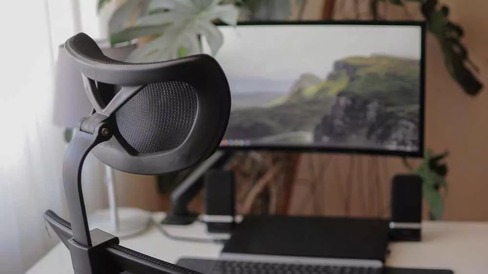 Zakrivený monitor GIGABYTE GS32QCA na pracovnom stole za ergonomickým kreslom.