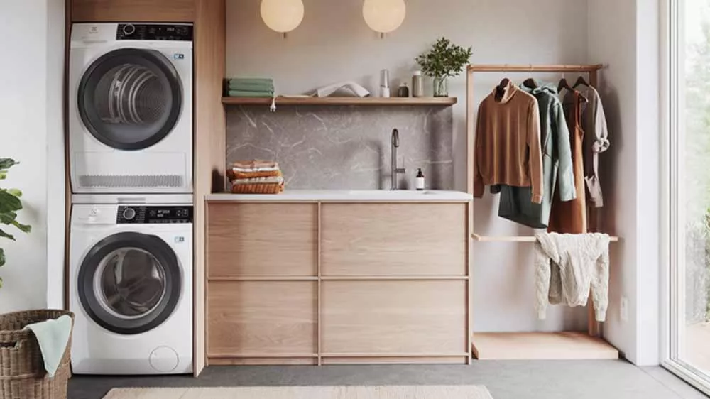 Su&scaron;ička bielizne Electrolux umiestnen&aacute; na pr&aacute;čke pomocou spojovacieho medzikusu v modernej pr&aacute;čovni.