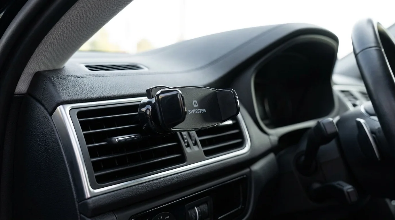 Černý držák telefonu Swissten S-GRIP AV-2 upevněný v mřížce ventilace automobilu.